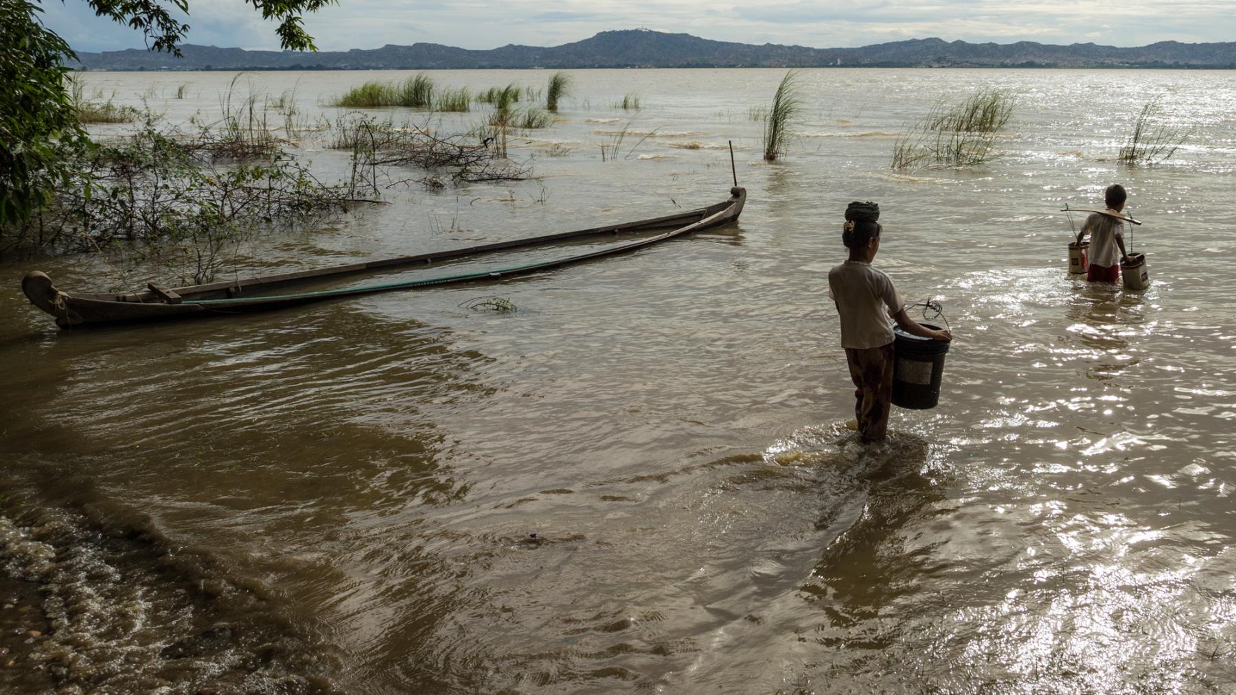 A woman and boy collect river water in Myanmar